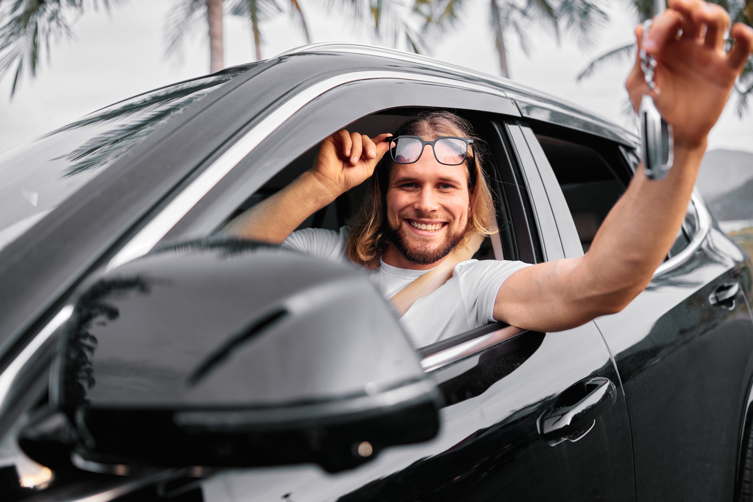 smiling man holding sunglasses in a car surrounde 2025 03 11 12 56 32 utc scaled