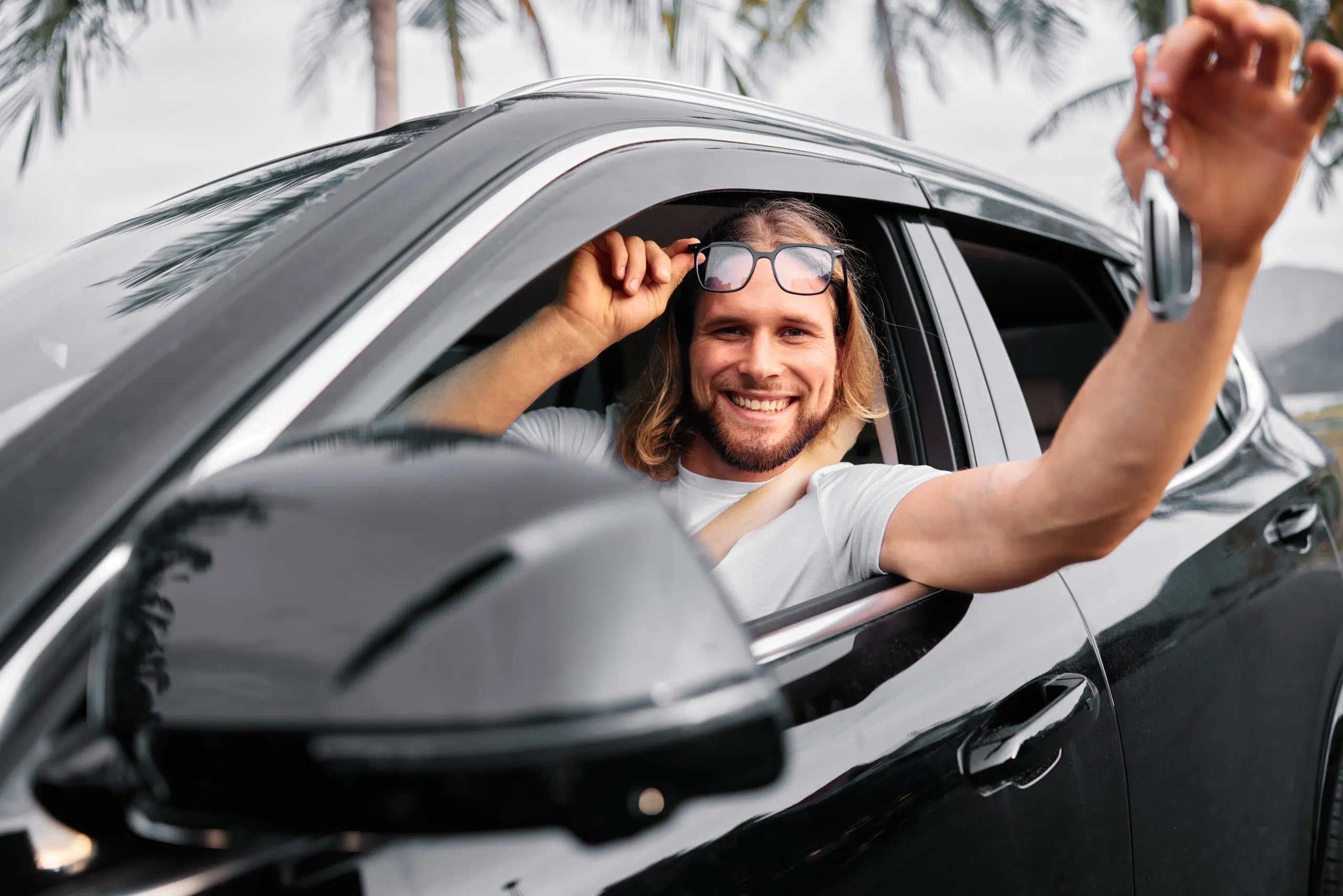 رجل مبتسم يحمل نظارة شمسية داخل سيارة محاطة بـ 2025/03/11/12:56:32 بالتوقيت العالمي المنسق (UTC)