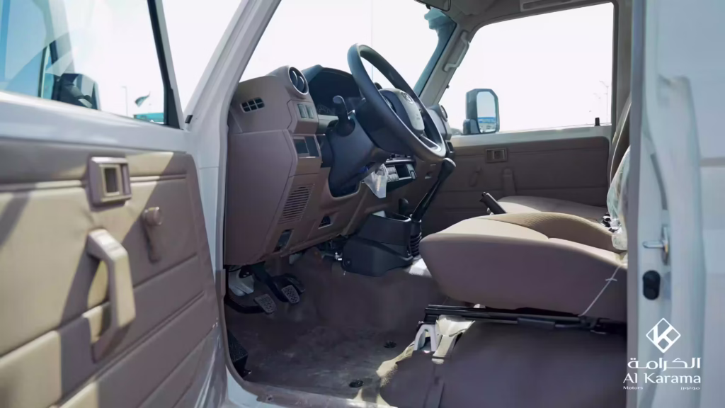 Driver cabin of 2026 Toyota LC78 with brown fabric seats and manual transmission
