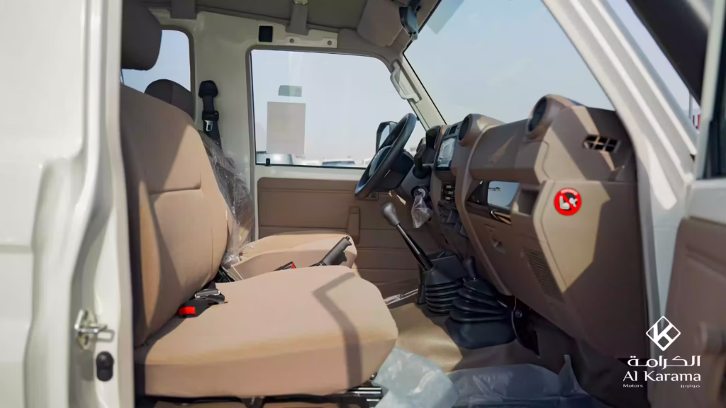 Front seating area of 2026 Toyota LC78 with brown fabric seats and manual gear levers