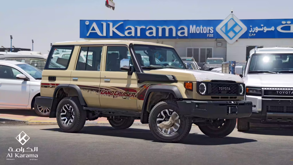 Beige 2026 Toyota Land Cruiser LC76 2.8L Diesel Hardtop parked in front of Al Karama Motors dealership