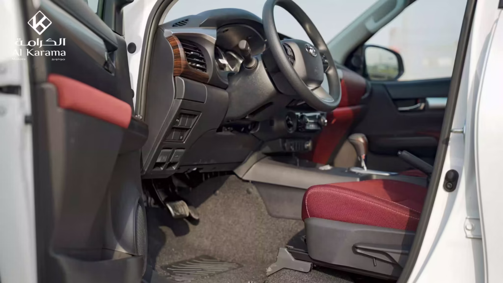 Driver-side interior of 2026 Toyota Hilux V6 with red seats